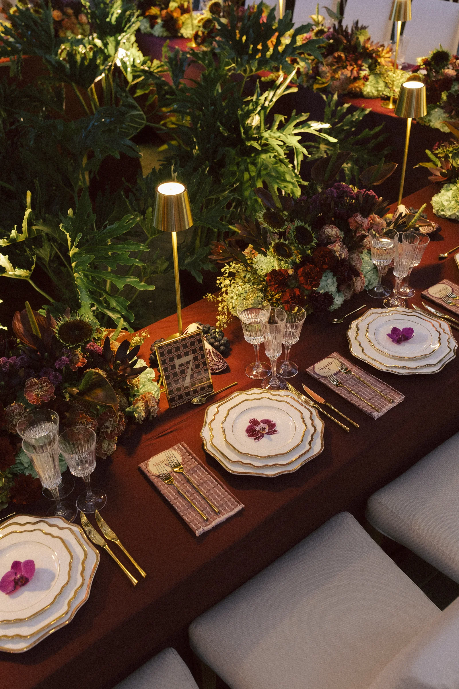 Table with orchids and brass lamps at Orquideorama