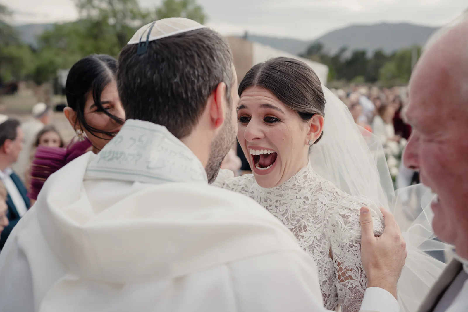 Simón and Lorena laughing under the tallit